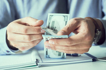 Businessman count the new us dollars paper money. Form of a bribe or salary.