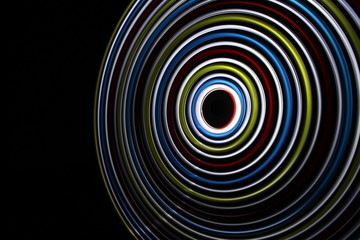 Rainbow LED light spinning on long exposure shot in the dark.
