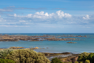 Fototapeta na wymiar Looking out to a rocky coastal landscape on the island of Jersey, on a sunny summers day
