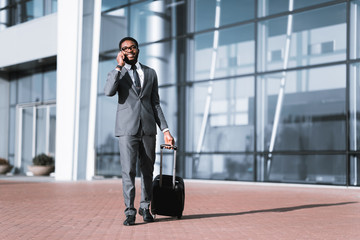 Calling Taxi. Businessman Arriving At Airport, Walking Outdoors