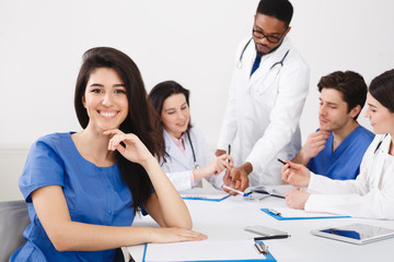 Fototapeta premium Meeting Of Medical Pros. Nurse Smiling To Camera At Meeting