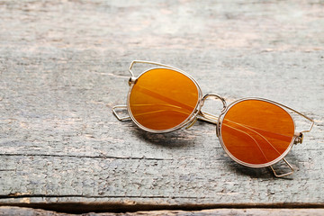 Fototapeta na wymiar Fashion sunglasses on grey wooden table