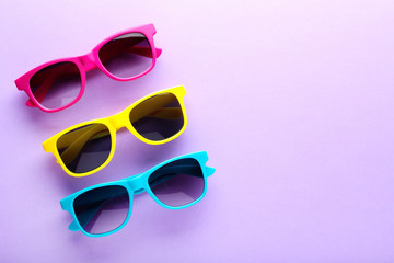 Colorful sunglasses on purple background