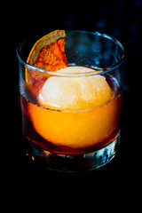 A healthy measure of rum over a big ice ball made of apple juice in a short glass