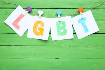 Paper with abbreviation LGBT on green background