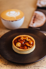 A cup of latte, cappuccino or espresso coffee with milk put on a wood table with piece of chocolate brownie cake