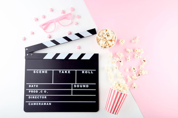 Clapper board with popcorn and pink glasses