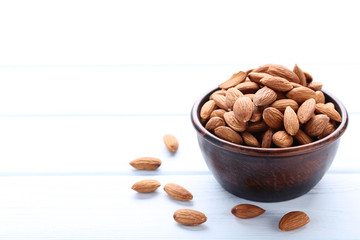 Almonds in bowl on white wooden table