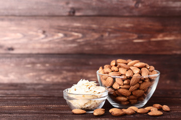 Fototapeta na wymiar Almonds in bowls on brown wooden table