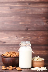 Almond and milk in bottle on brown wooden table