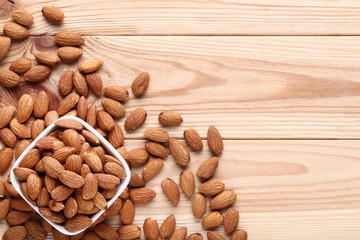 Almonds in bowl on brown wooden table