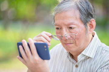 Older man watch video by cellphone