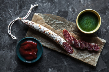 Slices of french saucisson/salami on a grey background.