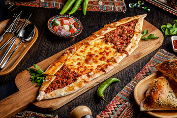 Traditional Turkish cuisine. Turkish pizza Pita with a different stuffing, meat, cheese, slices of veal. Turk Pidesi or Sucuk Pide. Serving dishes in the restaurant. Copy space