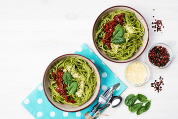 Pasta with spinach creamy sauce, sun-dried tomatoes and cheese. Useful tasty homemade food. Selective sharpness, shallow depth of field. Author's retouch