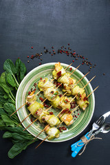 Rolls of zucchini, with chicken and cheese under spices and herbs. Place for text. Selective sharpness, shallow depth of field. Author's retouch