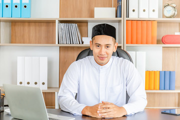 Selective focus of Happy young business arab middle eastern muslim man in office