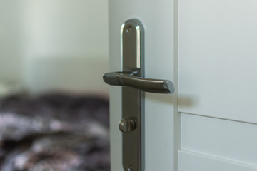 Opened white wooden door to modern bedroom interior. Modern room interior blur background.