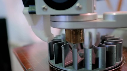 3D printing, additive technologies, industrial and manufacturing concept - 3D printer machine printing plastic workpiece look like metal at futuristic technology exhibition - close up shot