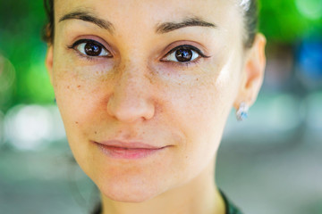 Outdoors portrait of a beautiful brown-eyed young woman with long brown hair
