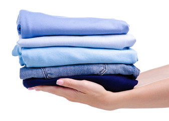 Stack blue folded clothing in hand on white background isolation