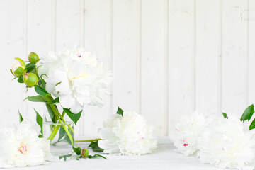 Naklejka na ściany i meble White tender background with peonies on the wooden table