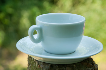 White coffee cup on a concrete pillar in nature.Coffee time