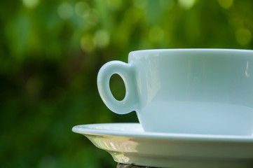 White coffee cup on a concrete pillar in nature.Coffee time