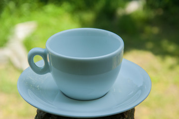 White coffee cup on a concrete pillar in nature.Coffee time