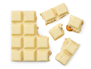 Broken white chocolate bar with nuts on a white. View top