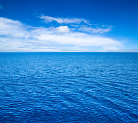 Obraz premium clouds on blue sky over calm sea with sunlight reflection