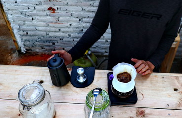  coffee brewing, step by step. Barista gently pours hot water on the surface of the ground coffee. Wetting the coffee