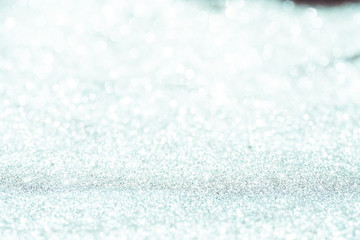 silver Sparkling Lights Festive background with texture. Abstract Christmas twinkled bright bokeh defocused and Falling stars. Winter Card or invitation