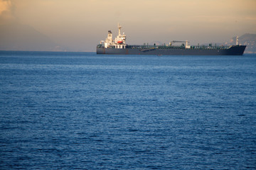 View of the huge sea liner in the harbor on the background of the sunset on the sea