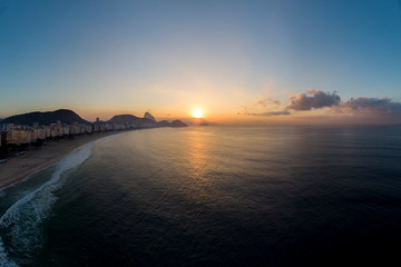 Aerial view of Copacabana beach and neighbourhood at early sunrise with the sun on the horizon next...