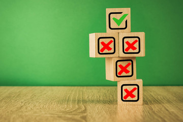 wooden cubes with the image of check marks marks on a green background.