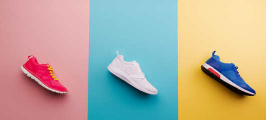 A studio shot of running shoes on bright color background. Flat lay. - obrazy, fototapety, plakaty