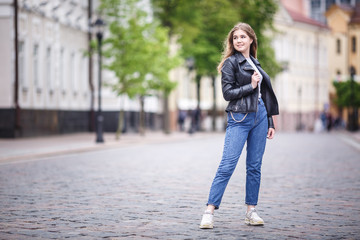 portrait of little beautiful stylish kid girl in city urban street