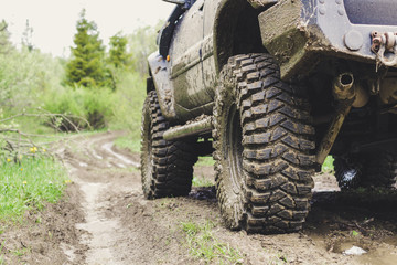 Fototapeta premium Dirty cars and wheels in the mountains. Swamp on the tires. Trips offroad across Ukraine. View of the Carpathian Mountains.