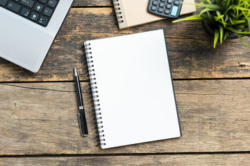 Empty notebook with smart phone and computer on wooden table top view.