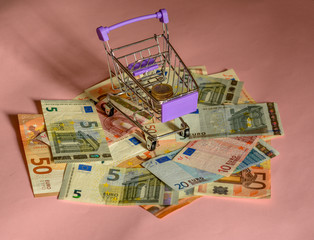 trolley for a supermarket, euro banknotes pink background