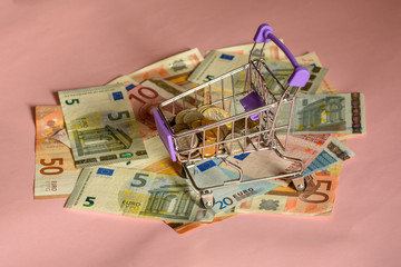 trolley for a supermarket, euro banknotes pink background
