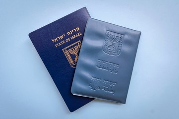 Israeli official documents: passport of Israel and national ID document on a light blue background with a small flag of Israel. Israel citizenship concept