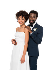 smiling african american bridegroom and bride looking at camera isolated on white