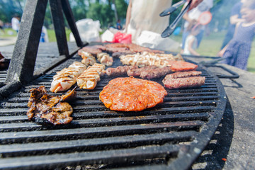 Grilled burger and chicken meat on barbecue at picnic