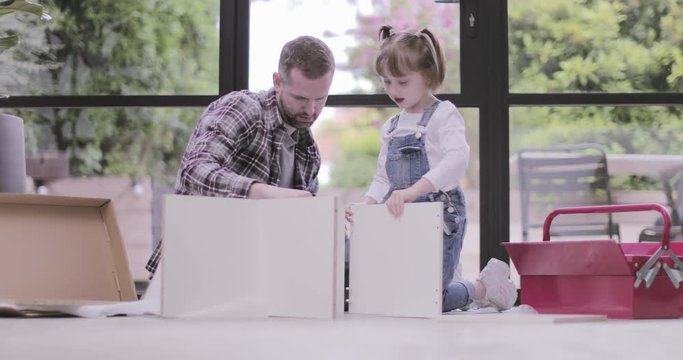 Father and daughter building flat pack furniture