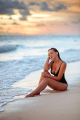 Fototapeta na wymiar Happy Carefree Woman Enjoying Beautiful Sunset on the Beach