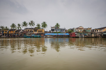 View across the river towards Hoi An, Vietnam with fishing boats moored