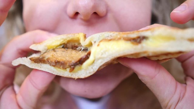 Closeup Of Woman Eating Vegan Panini Sandwich With Veggie Bacon And Melted Cheese.