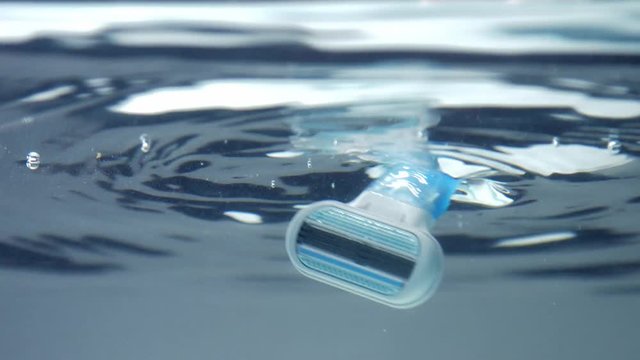 closeup of shaver immerced ino water. underwater view with water surface reflecting
